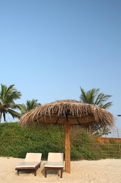 Due posti al paese tropicale con ombrellone sulla spiaggia