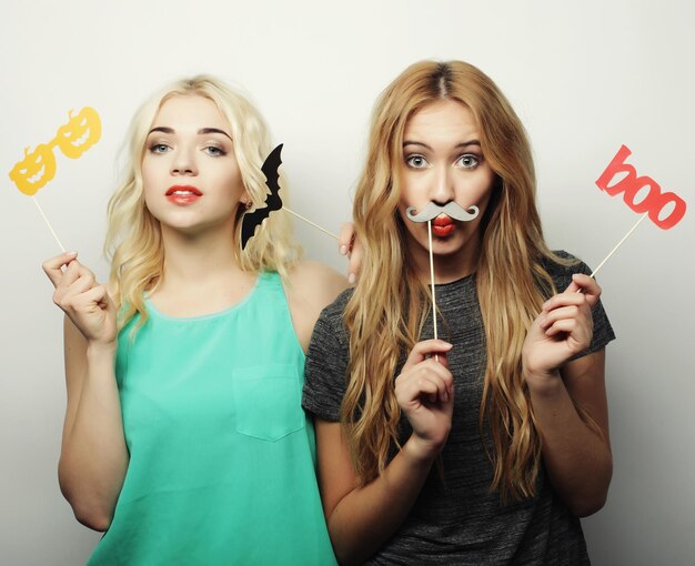 Due ragazze alla moda sexy hipster migliori amiche pronte per la festa su sfondo grigio