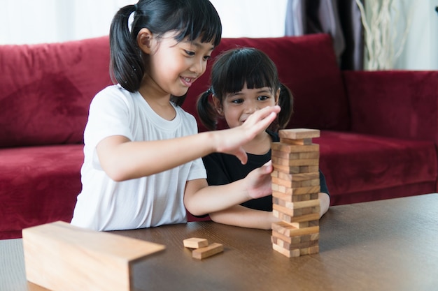 Due ragazze asiatiche che giocano a pile di legno a casa