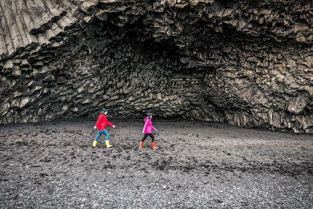 Due ragazze camminano sulla spiaggia di Reynisfjara in Islanda