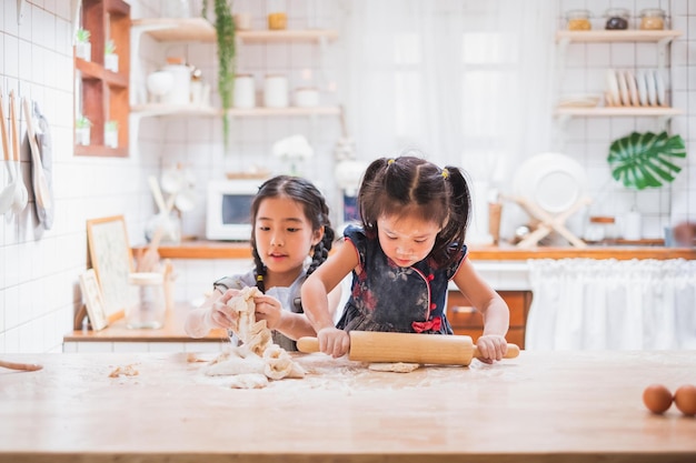 Due ragazze carine che fanno la torta cucinando in cucina a casa