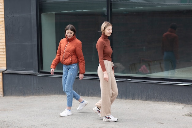 Due ragazze che camminano per la strada della città. Giovane donna all'aperto.
