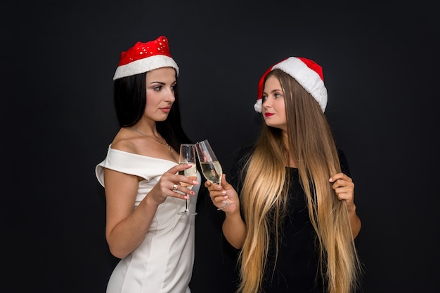 Due ragazze che celebrano il nuovo anno in cappelli della santa