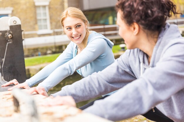 Due ragazze che fanno allungando gli esercizi all&#39;aperto a Londra