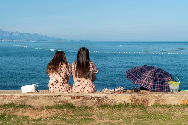 Due ragazze che guardano il mare durante i loro viaggi