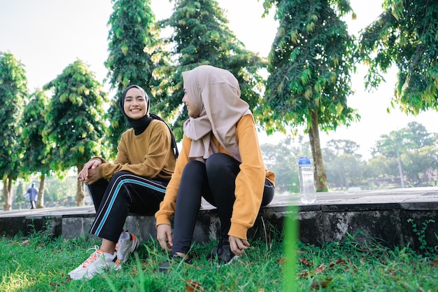 Due ragazze che indossano l'hijab sorridono e si godono il pomeriggio dopo essersi esercitate insieme nel parco