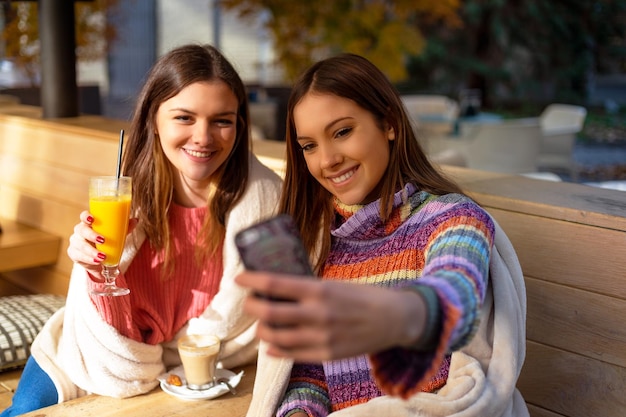 Due ragazze che si fanno selfie sorridendo divertendosi