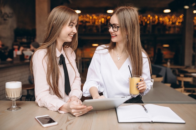 Due ragazze che studiano in un caffè