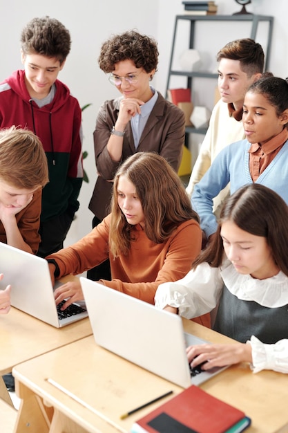 Due ragazze che usano il computer portatile con i tappetini di classe