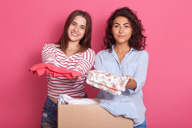 Due ragazze degli amici che tengono i vestiti nelle mani