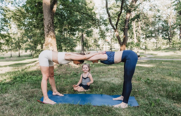 Due ragazze e una bambina fanno sport in un parco all'aperto. uno stile di vita sano