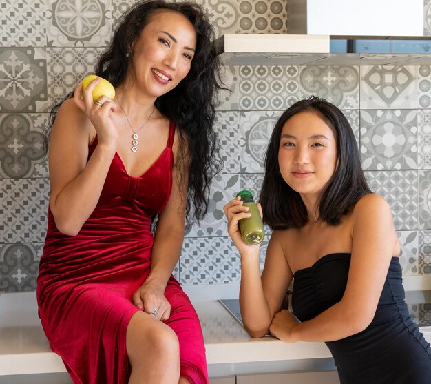 Due ragazze eleganti in posa con uno spuntino guardando la telecamera, ritratto orizzontale