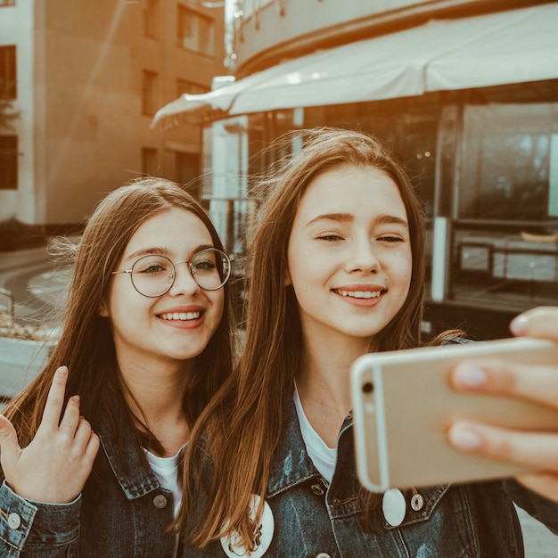 Due ragazze felici migliori amiche in streaming video in diretta sulla strada della città