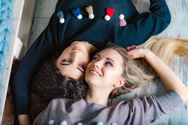 Due ragazze giacciono sul letto e sorridenti Sorelle felici Natale Buon Natale concetto