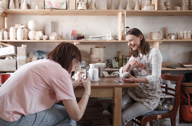 Due ragazze girano un video blog in un laboratorio d'arte mentre realizzano giocattoli di legno