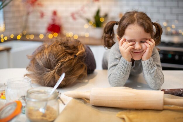 Due ragazze in piedi in cucina che cuociono i biscotti di Natale