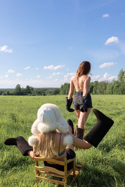 Due ragazze in un campo con stivali da pecora