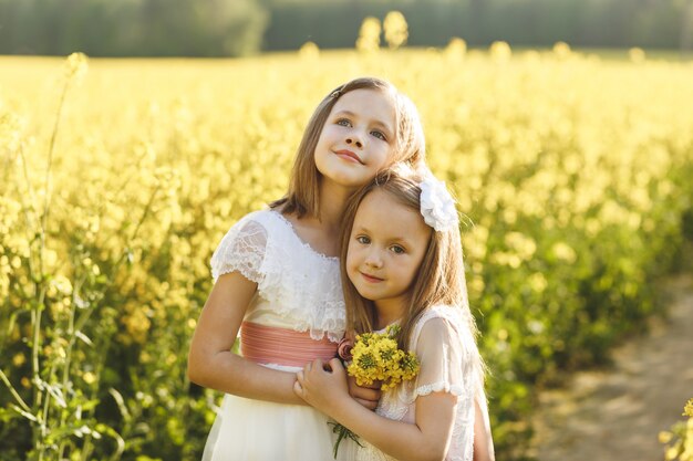 due ragazze in un campo di colza in estate