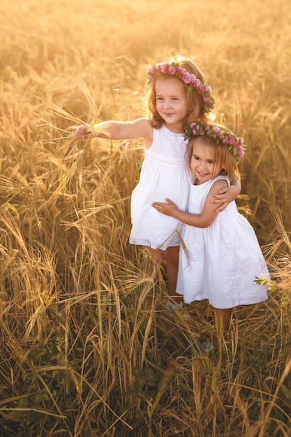 Due ragazze in un campo di grano, una delle quali punta in lontananza.