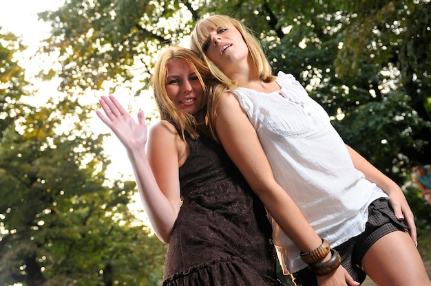 due ragazze insieme fuori in posizione di ballo pronte per la festa con bagliori di sole sullo sfondo