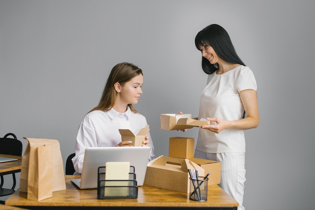 Due ragazze lavorano in ufficio e osservano la lavorazione degli imballaggi per alimenti