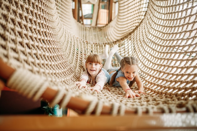 Due ragazze pone in rete di corda, centro giochi per bambini