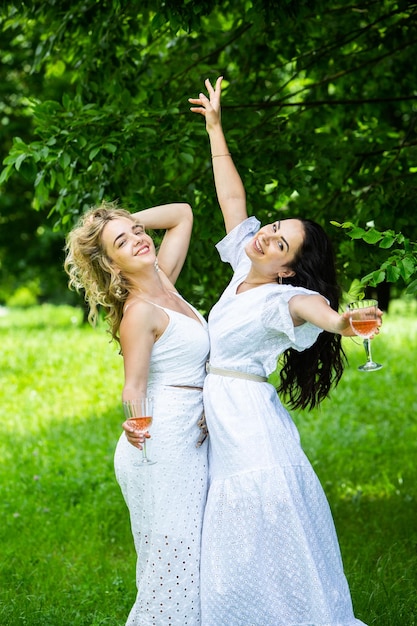 Due ragazze si riposano nel parco sedute su una coperta da picnic Amici sta facendo picnic all'aperto