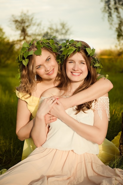 Due ragazze sorridenti e abbracci all'aperto in estate