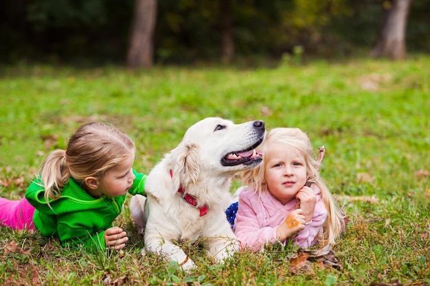 Due ragazze trascorrono del tempo con il loro cane obbediente