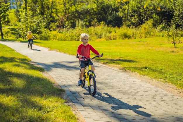 Due ragazzi felici in bicicletta nel parco.