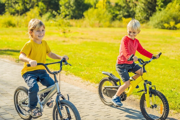 Due ragazzi felici in bicicletta nel parco.