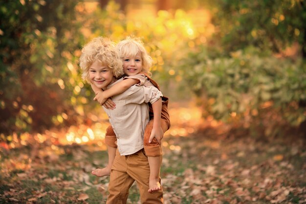 Due ragazzi felici stanno giocando nel parco all'inizio dell'autunno