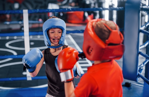 Due ragazzi in equipaggiamento protettivo hanno sparring e combattimenti sul ring.