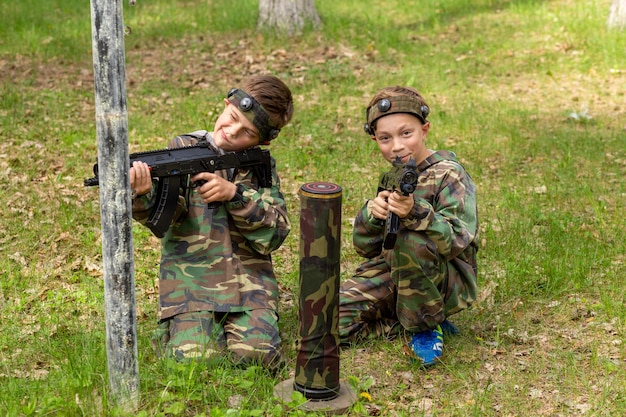 Due ragazzi indossati in tuta mimetica giocano a tag laser in uno speciale parco giochi nella foresta