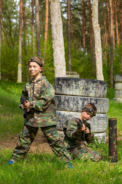 Due ragazzi indossati in tuta mimetica giocano a tag laser in uno speciale parco giochi nella foresta