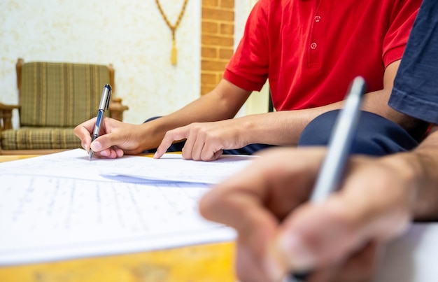 Due ragazzi seduti insieme a studiare e scrivere i compiti