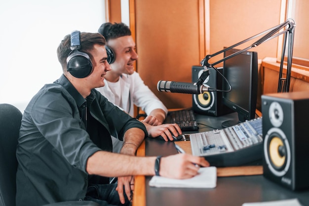 Due ragazzi sono al chiuso nello studio radiofonico occupato dalla trasmissione