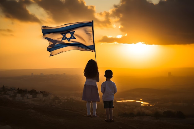 Due ragazzini con la bandiera d'Israele al tramonto
