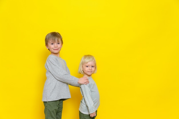 Due ragazzini di ottimo umore. Il fratello maggiore tiene il fratello per le spalle.