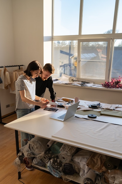 Due sarte lavorano in studio con campioni di tessuto per la nuova collezione di designer in atelier