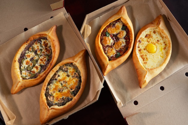 Due scatole artigianali con khachapuri adjarian. Concetto di consegna del cibo. Piatto nazionale georgiano