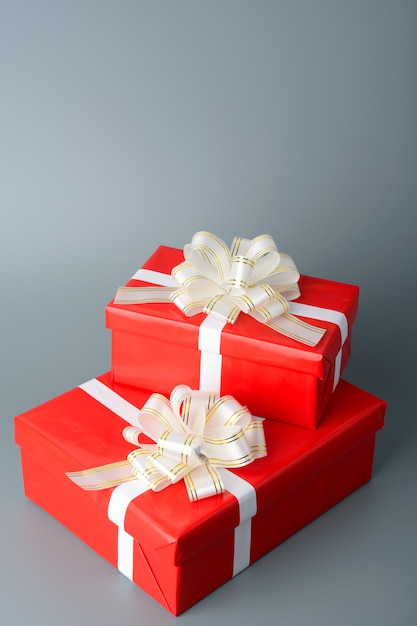 Due scatole regalo rosse con un nastro bianco e un fiocco