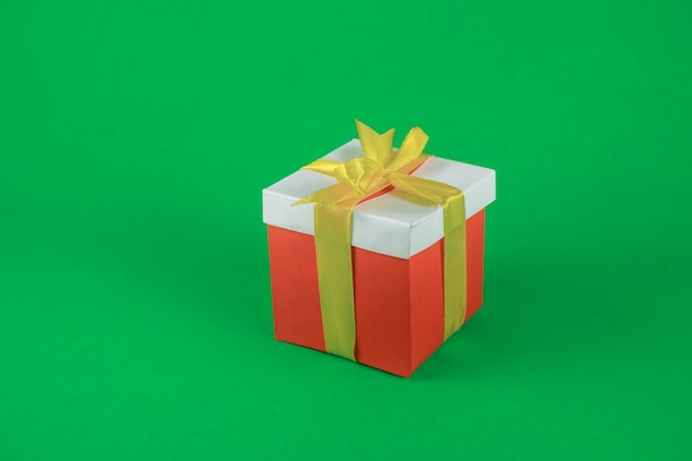 Due scatole regalo rosse e bianche con nastro d'oro su sfondo verde