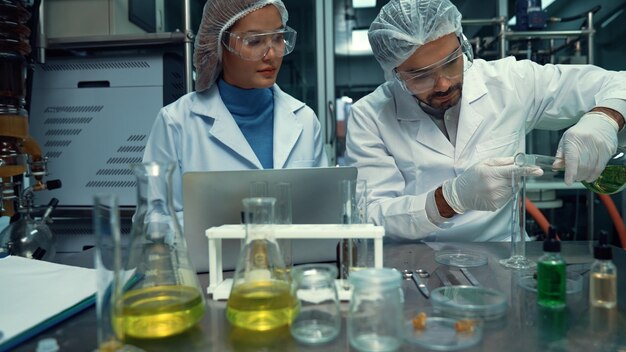 Due scienziati in uniforme professionale che lavorano in laboratorio