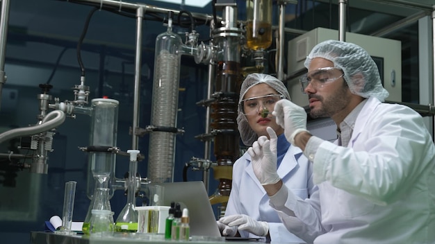 Due scienziati in uniforme professionale che lavorano in laboratorio