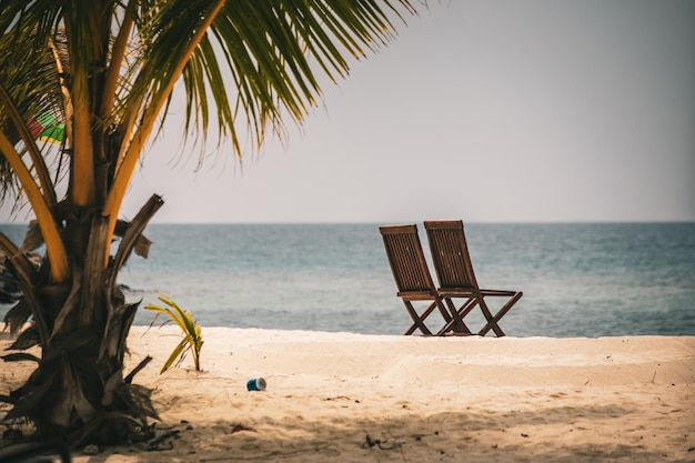 Due sedie vuote in riva al mare sulla spiaggia delle Maldive