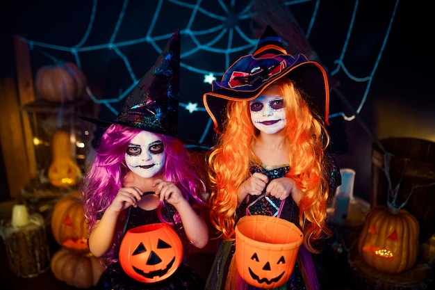 Due simpatiche sorelle divertenti celebrano la festa. Bambini allegri in costumi di carnevale pronti per Halloween.