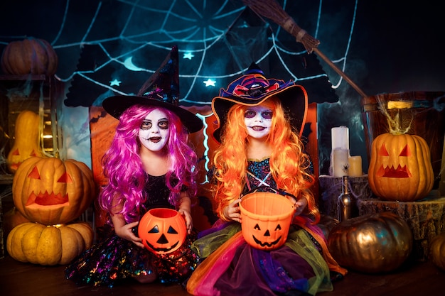 Due simpatiche sorelle divertenti celebrano la festa. Bambini allegri in costumi di carnevale pronti per Halloween.