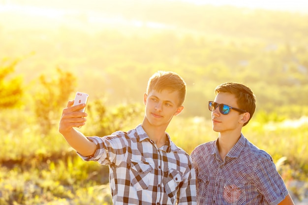 due simpatici ragazzi fanno selfie Gli amici felici sono fotografati al telefono