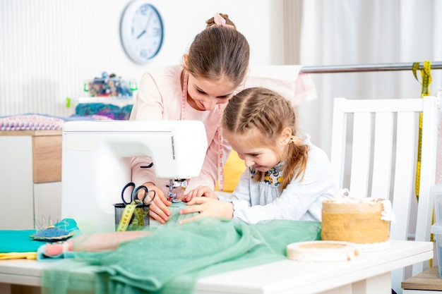 Due sorelle che lavorano su una macchina da cucire